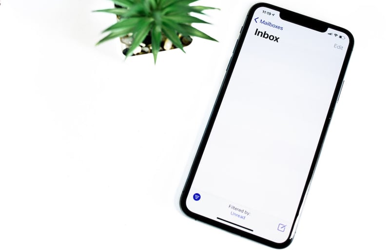 A phone with a mostly blank screen with just inbox in the top left corner