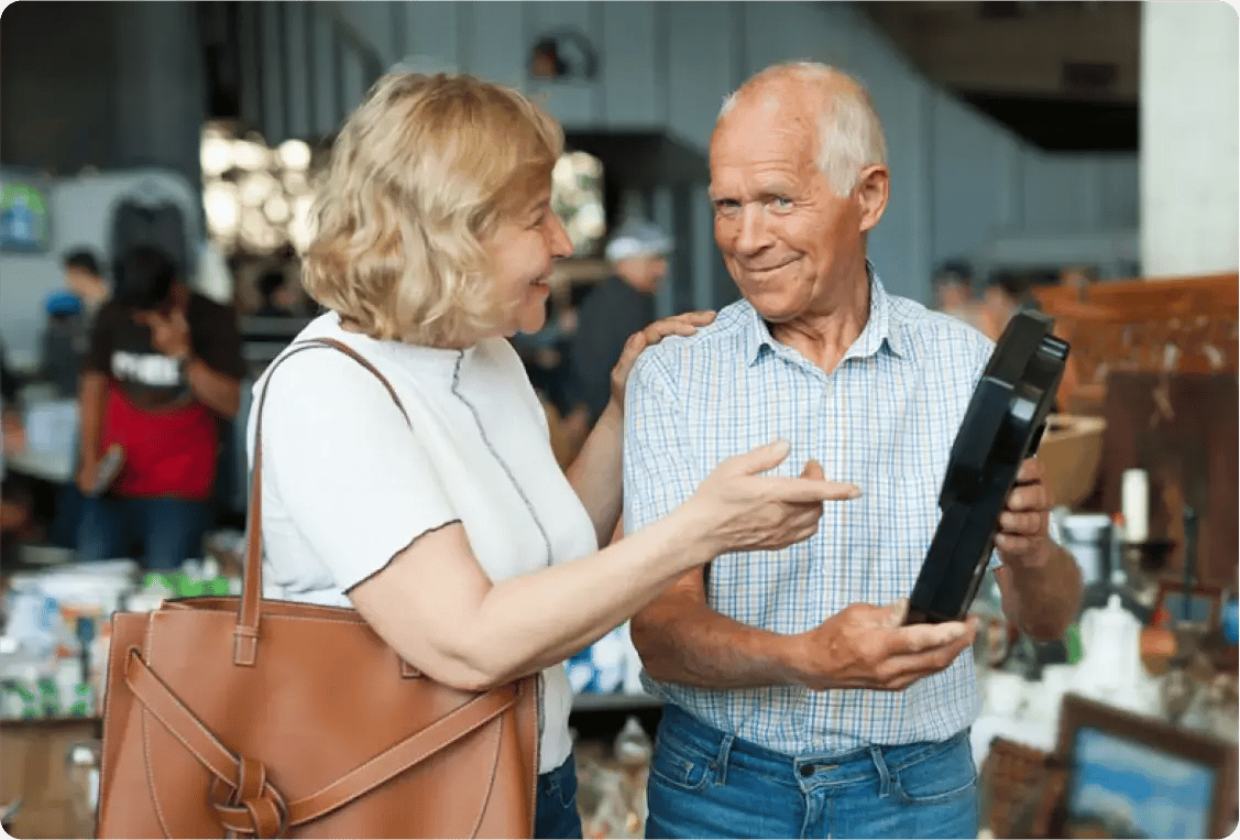 Smiling couple discussing an item at an estate sale