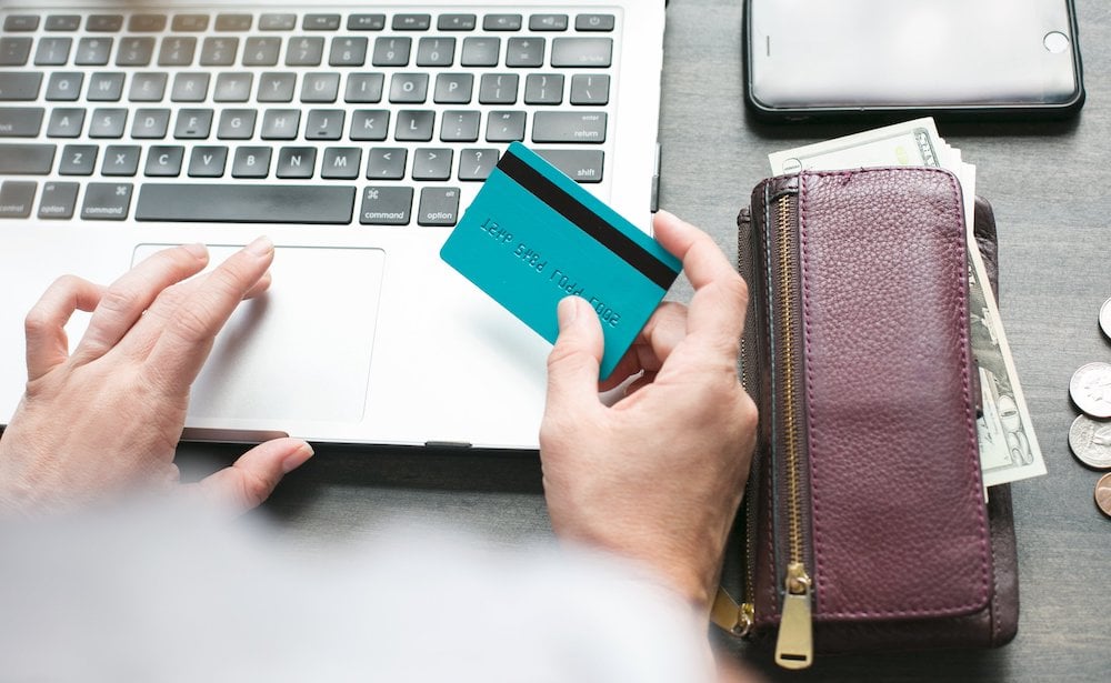 a person uses a blue bank card to shop online